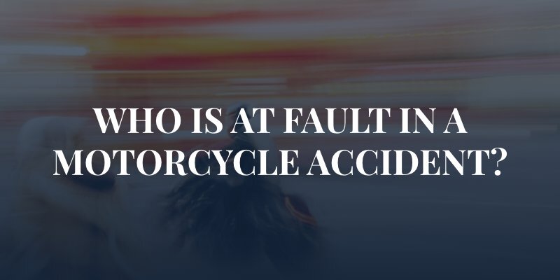 blurred motorcycle in traffic with the caption: "who is at fault in a motorcycle accident?"